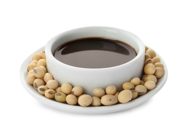 Dish of soy sauce with beans on white background