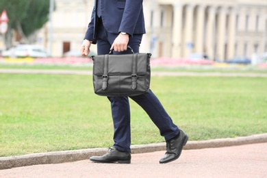 Photo of Businessman with black briefcase in hand outdoors