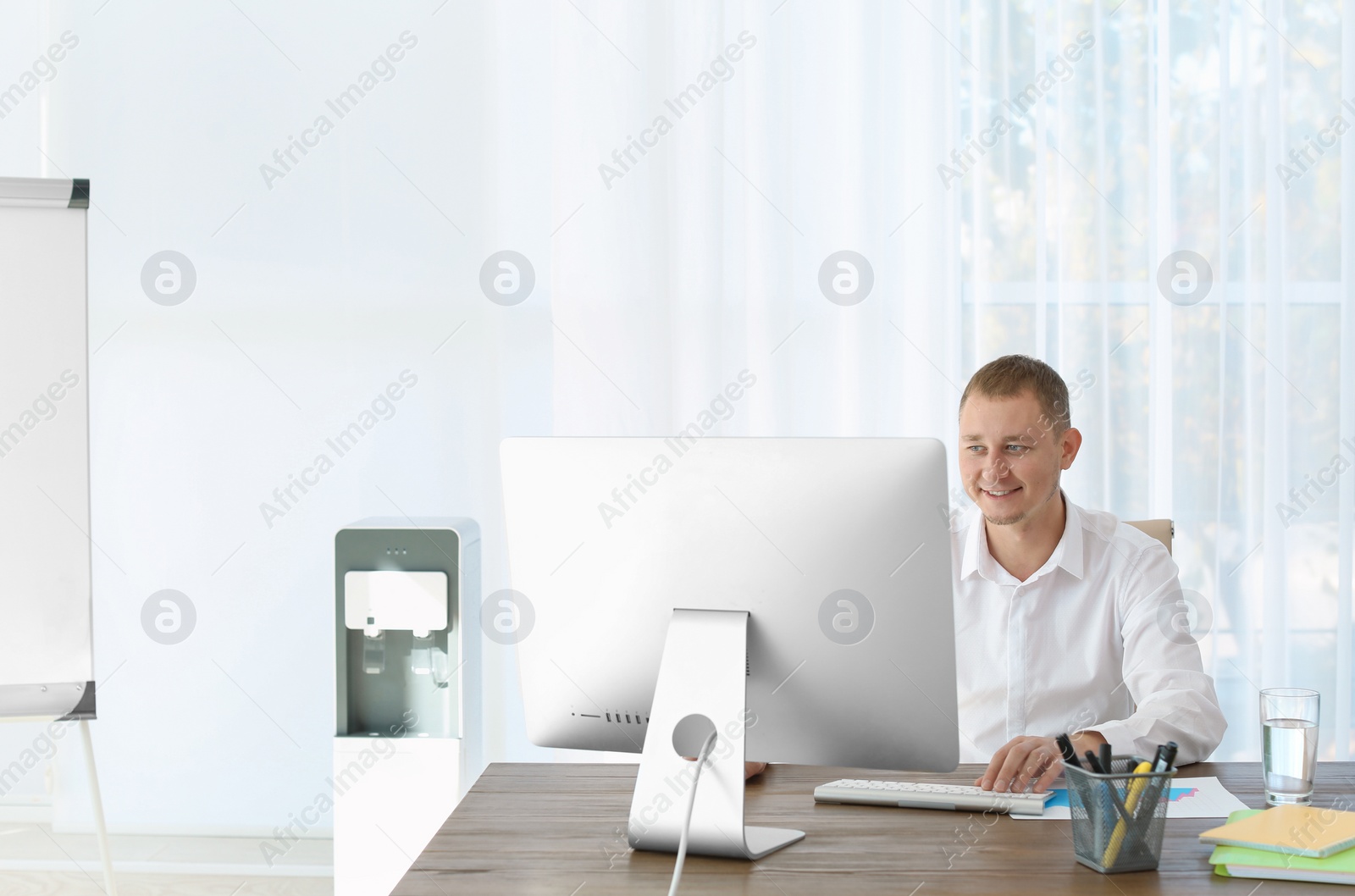 Photo of Office employee at desk near water cooler