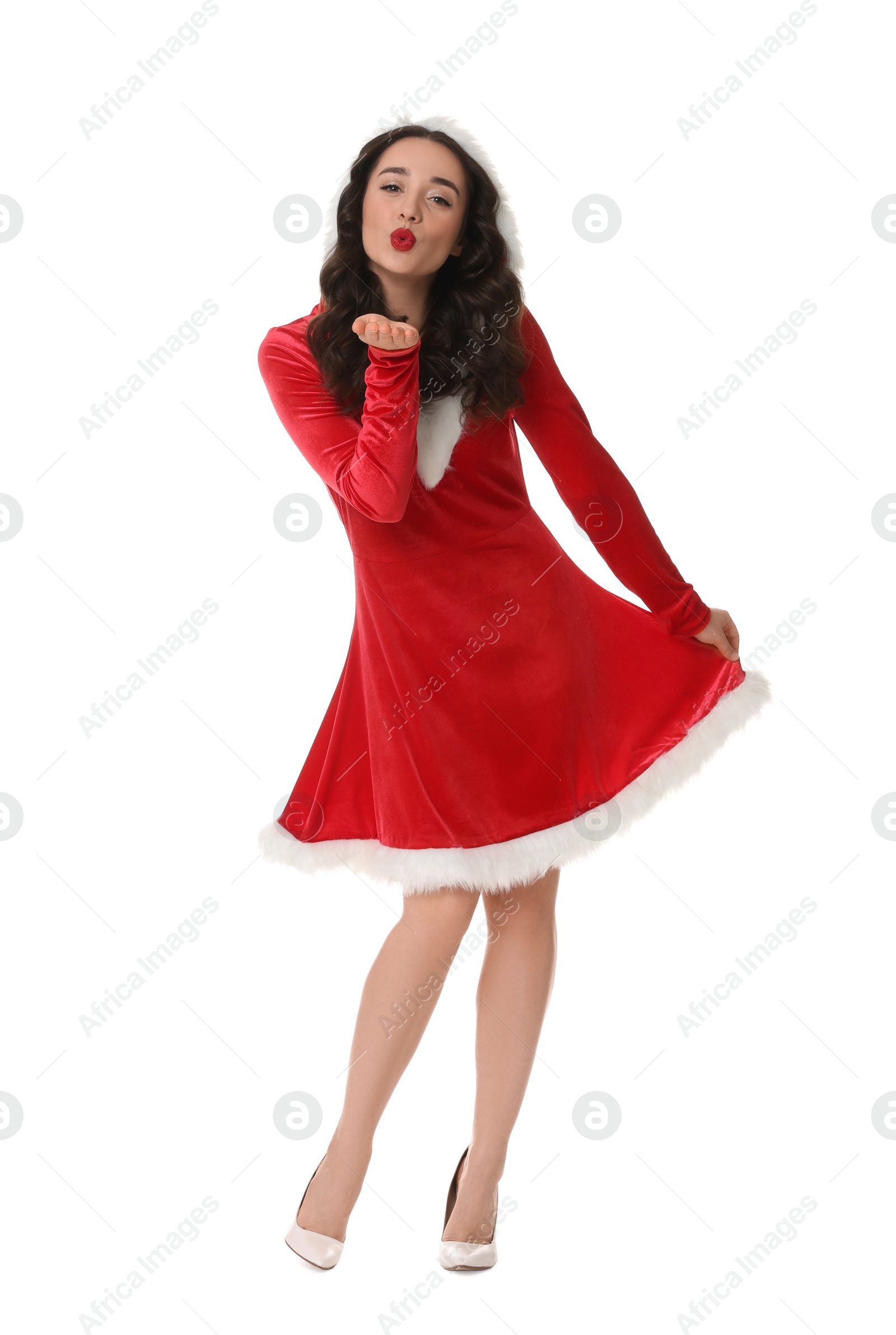 Photo of Beautiful young woman in Christmas red dress blowing kiss isolated on white