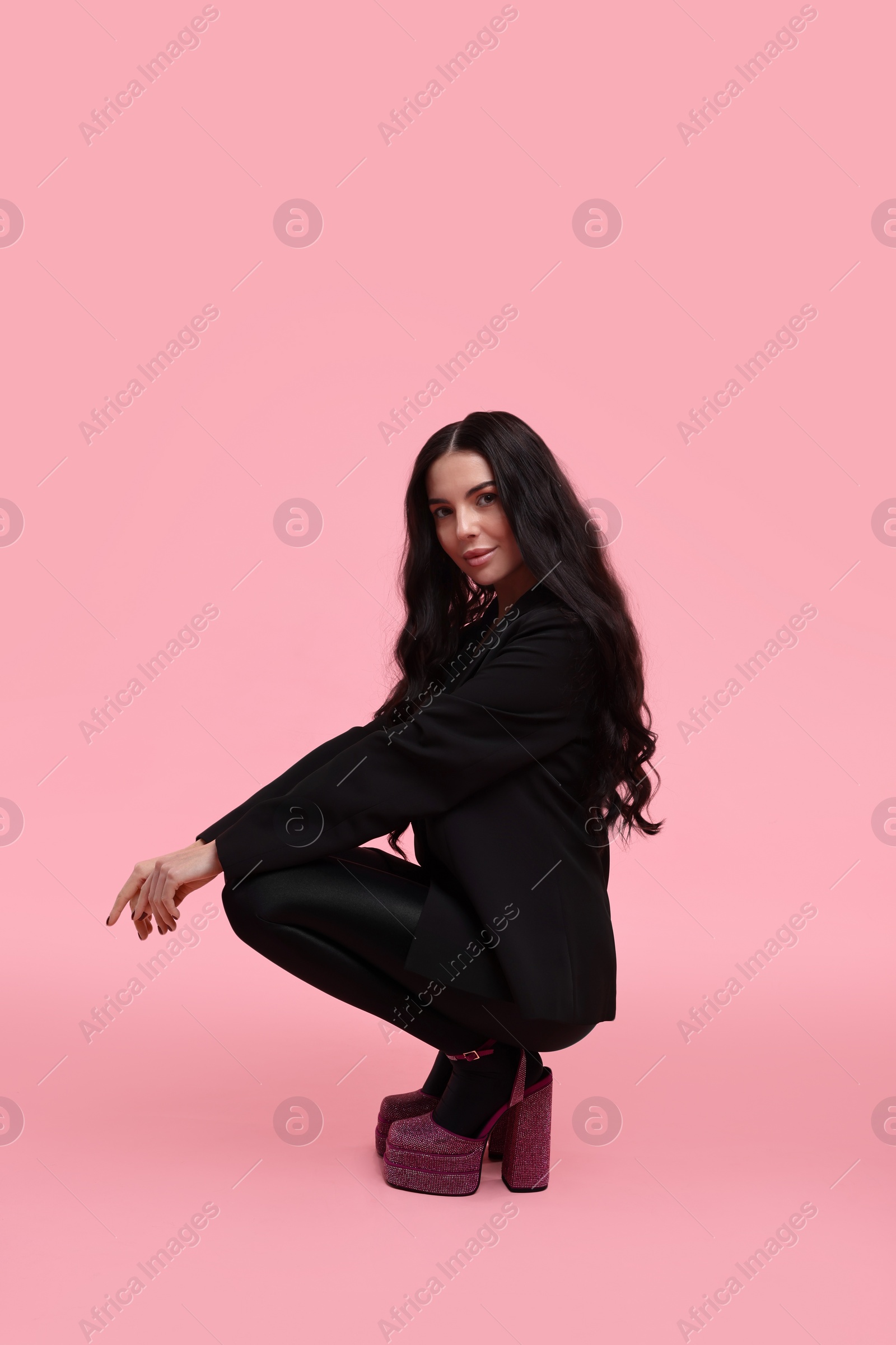 Photo of Stylish woman in black jacket on pink background