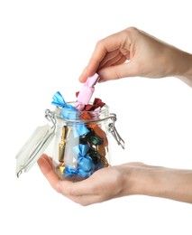 Photo of Woman taking candy in light pink wrapper from glass jar isolated on white, closeup