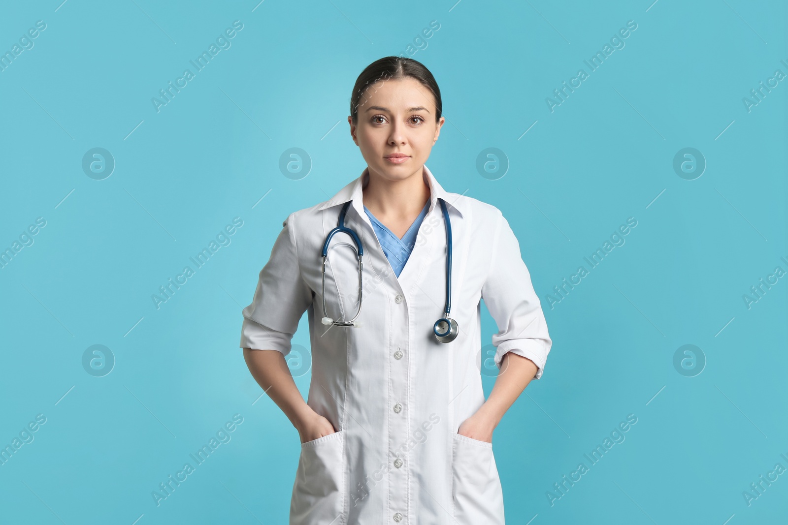 Photo of Pediatrician in uniform with stethoscope on turquoise background