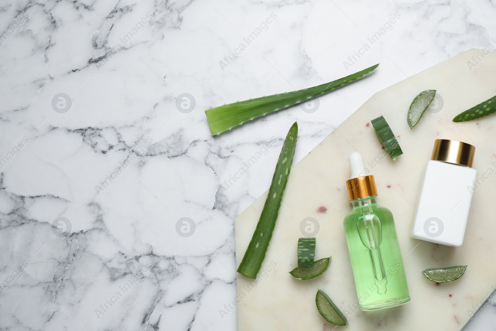 Photo of Flat lay composition with aloe vera and cosmetic products on white marble background. Space for text