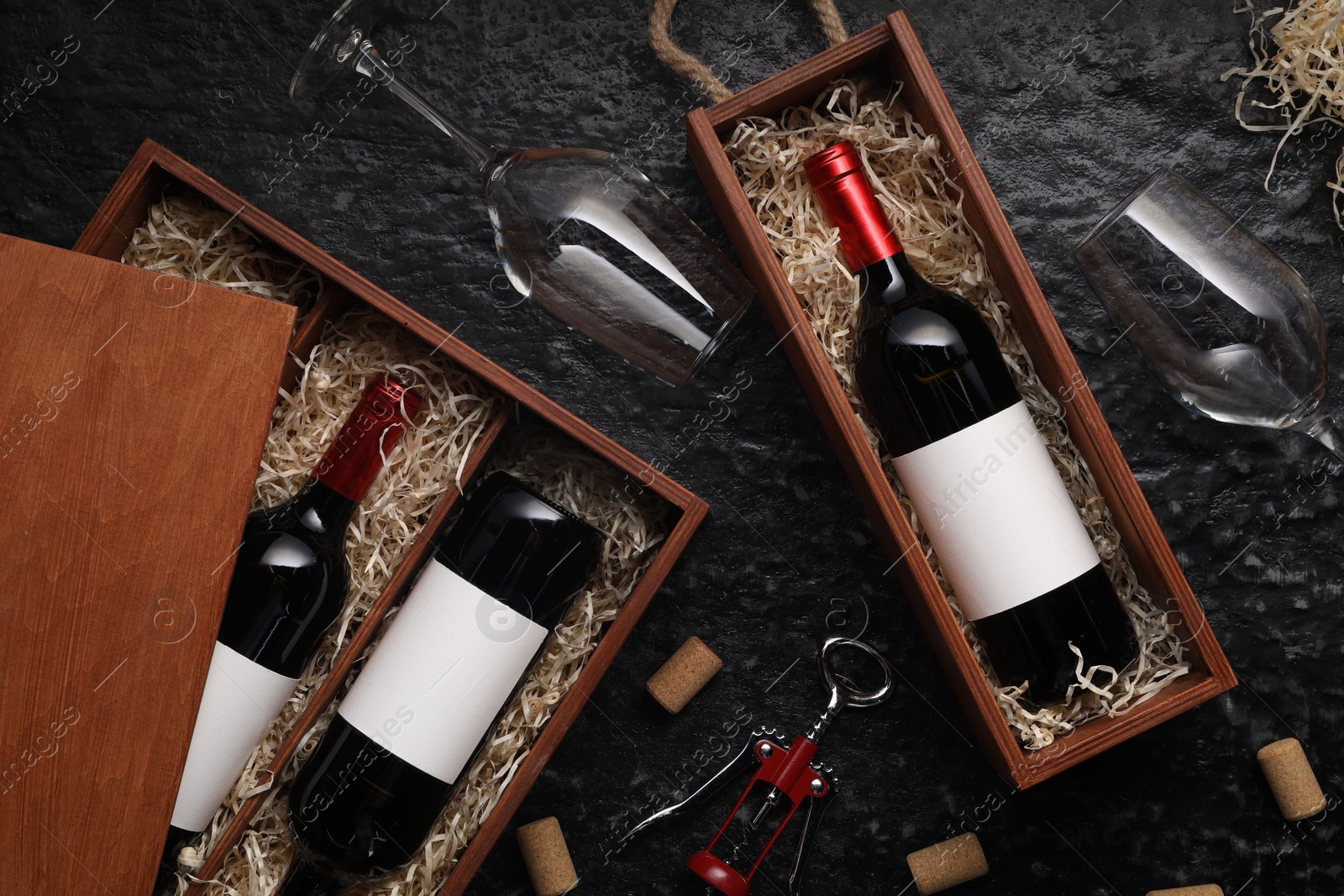 Photo of Flat lay composition with bottles of wine in wooden boxes on dark textured table