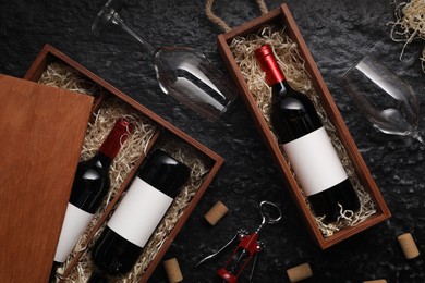 Photo of Flat lay composition with bottles of wine in wooden boxes on dark textured table