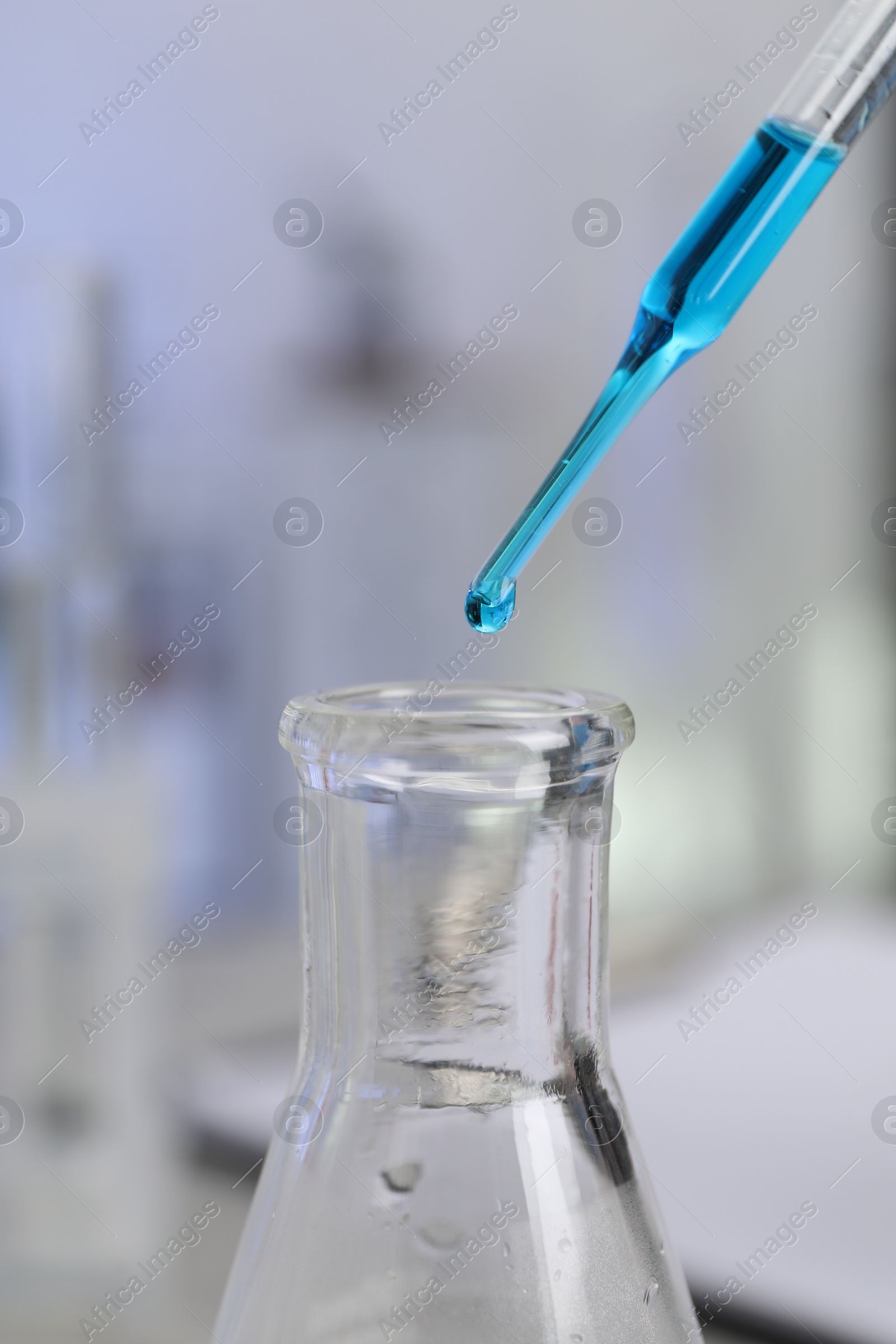 Photo of Laboratory analysis. Dripping liquid into flask on table, closeup