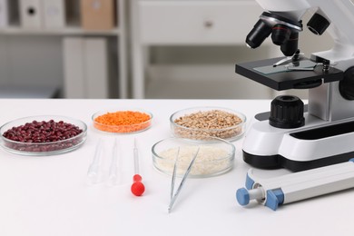Food Quality Control. Microscope, petri dishes with different products and other laboratory equipment on white table