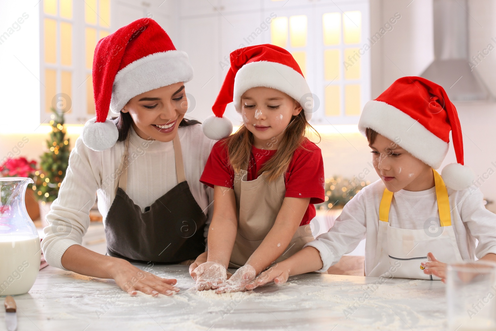 Photo of Mother with her cute little children making Christmas cookies in kitchen