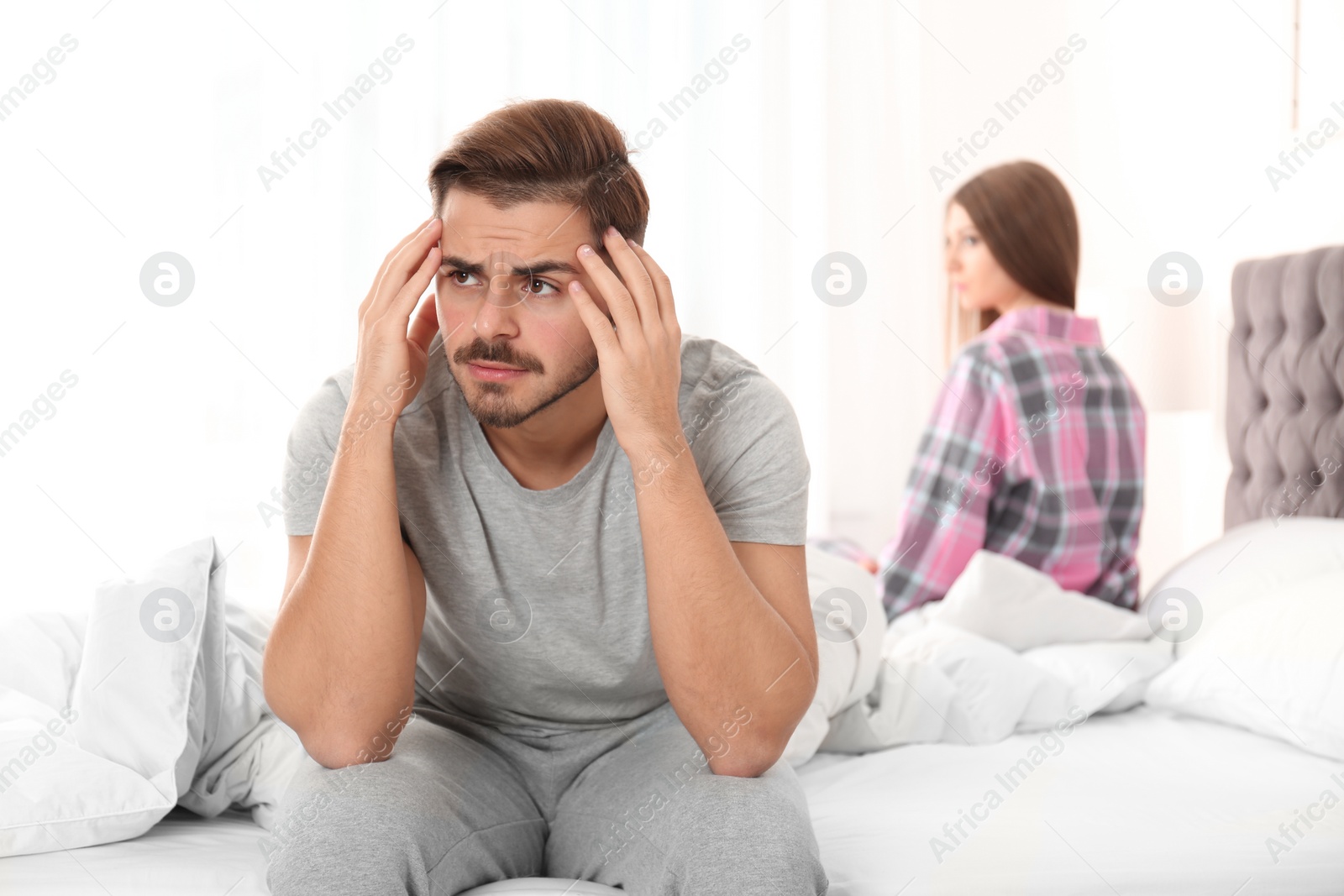 Photo of Young couple with relationship problems ignoring each other in bedroom