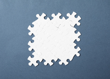 Photo of Blank white puzzle pieces on grey background, top view