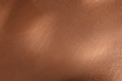 Photo of Plain rose gold surface as background, closeup