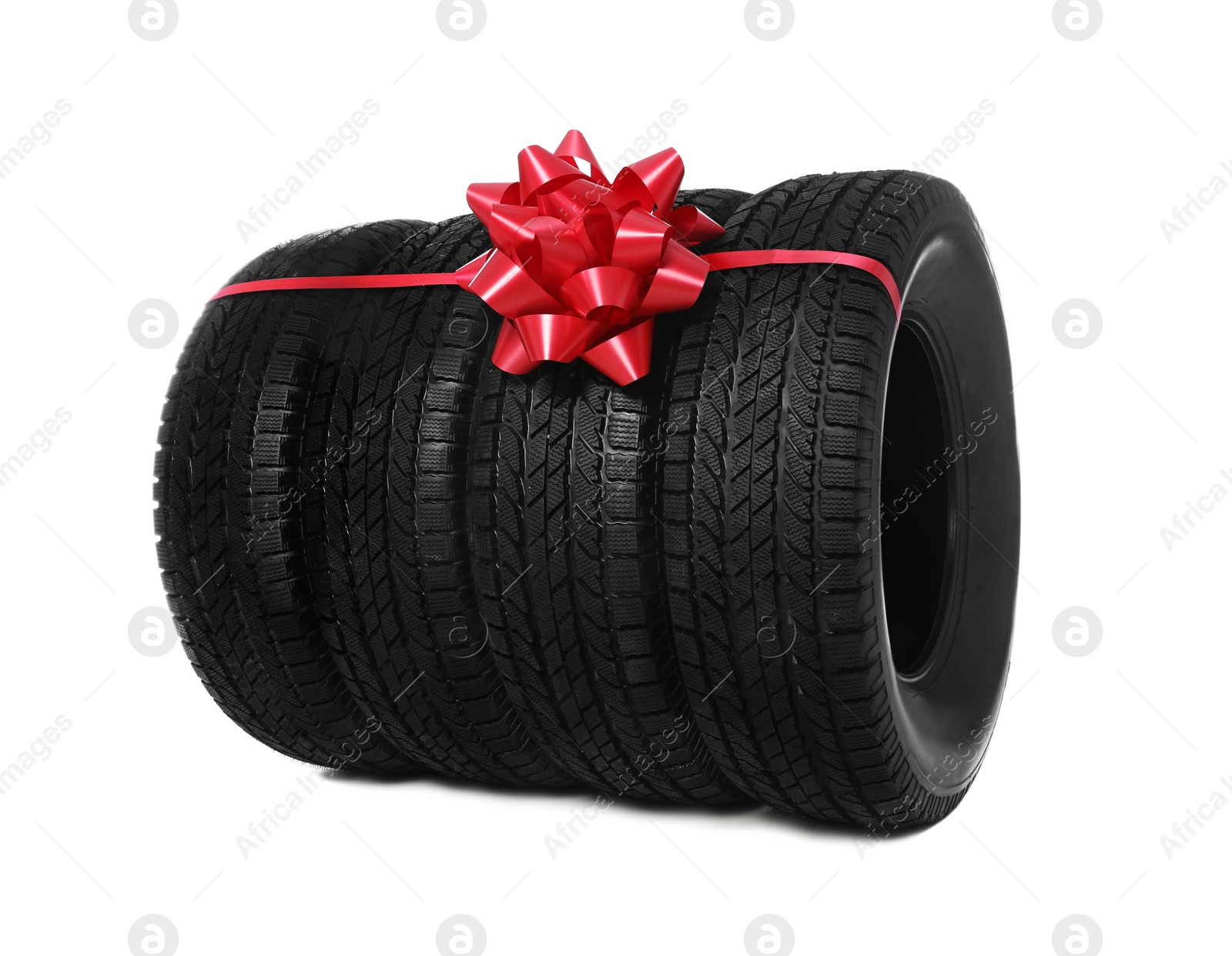 Photo of Winter tires with red ribbon on white background