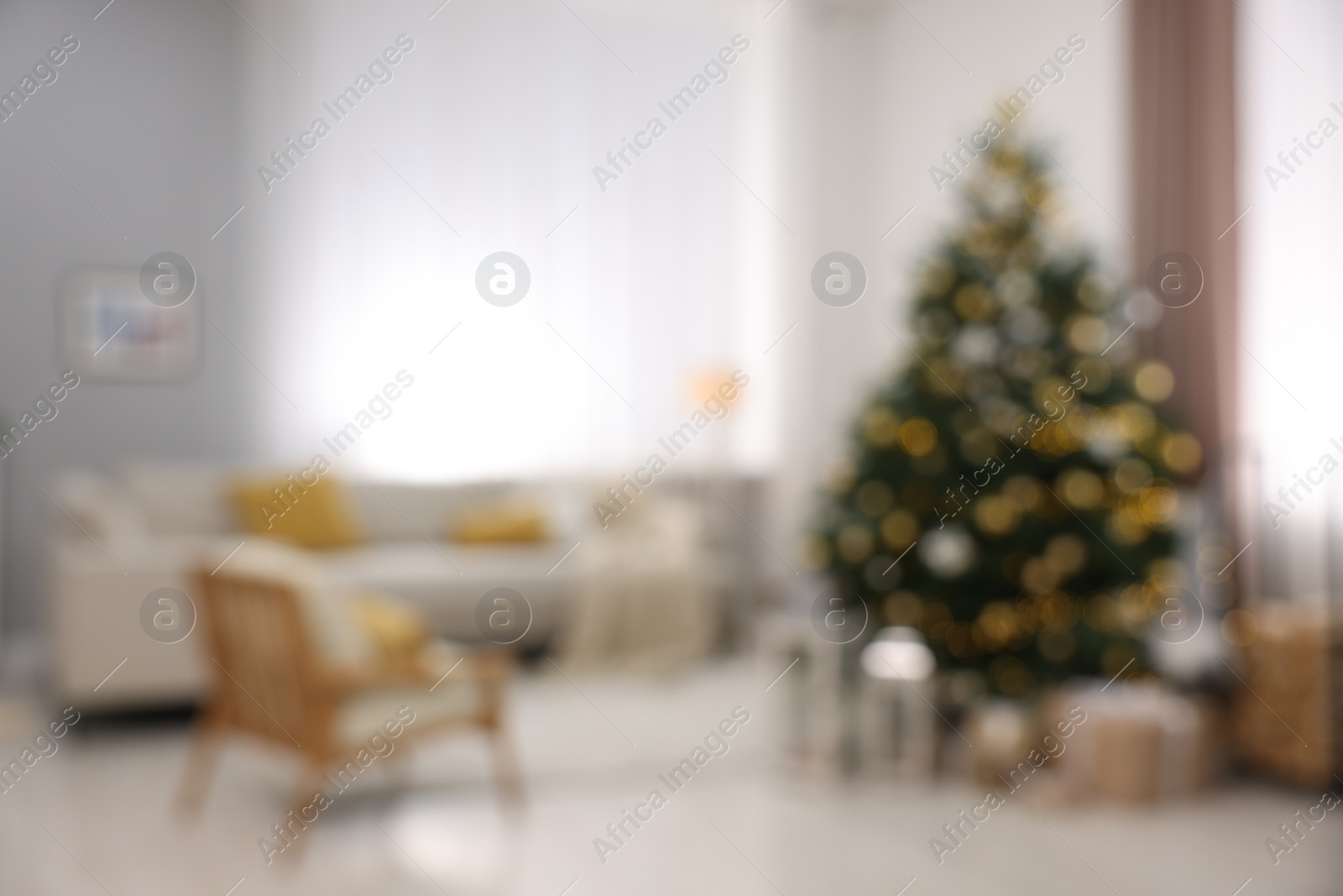 Photo of Christmas tree in furnished living room, blurred view. Festive interior design