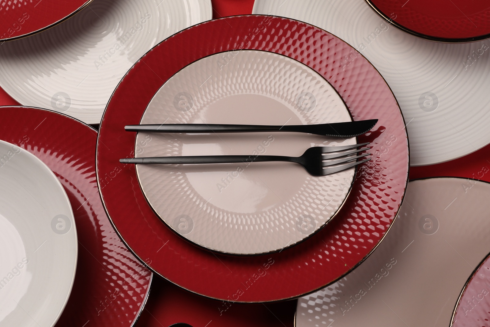 Photo of Stylish table setting with cutlery on red background, above view