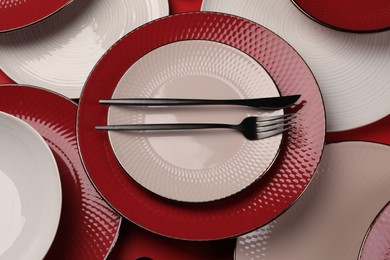 Stylish table setting with cutlery on red background, above view