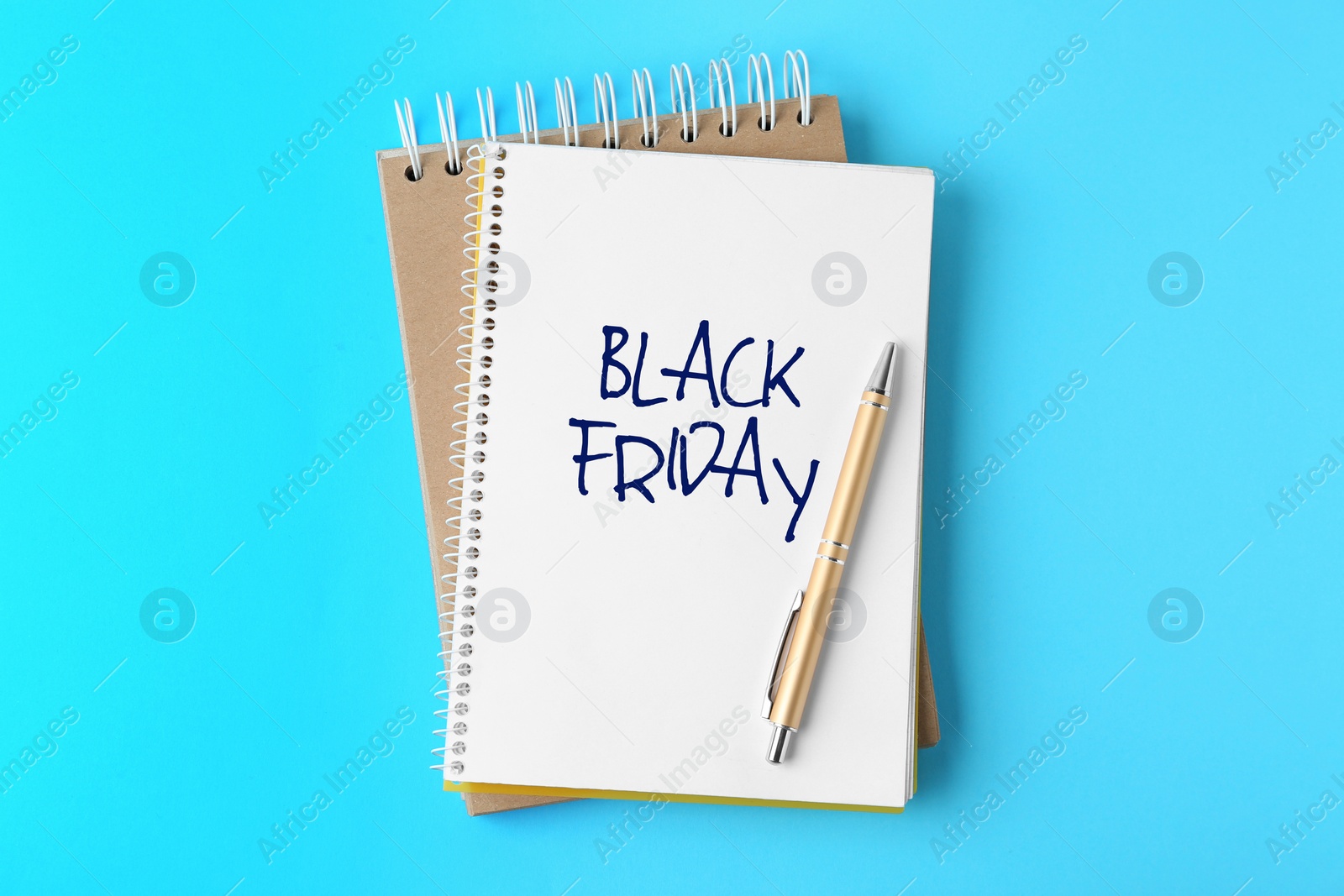 Image of Notebooks and pen on light blue background, top view. Black Friday Sale