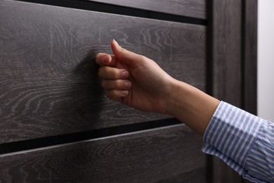 Photo of Woman knocking on door indoors, closeup view