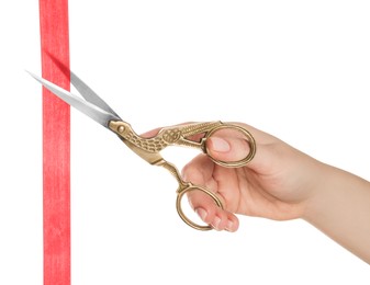 Woman cutting ribbon with beautiful scissors on white background, closeup