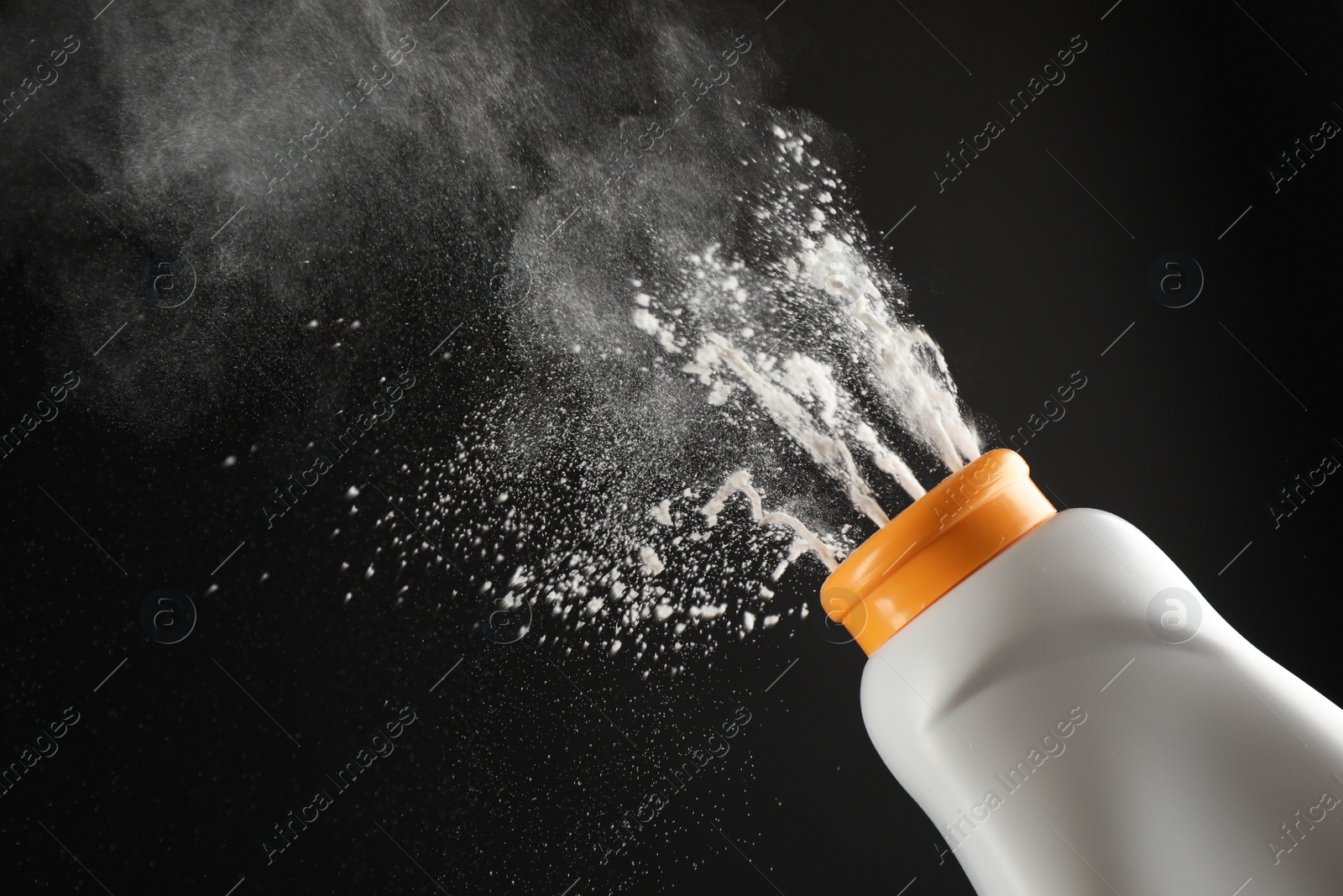 Photo of Scattering of dusting powder on black background