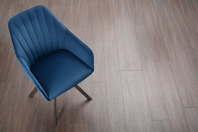 Photo of Stylish blue armchair on floor, above view. Space for text