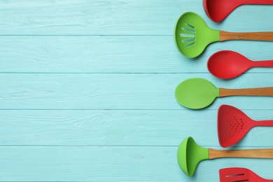 Photo of Set of modern cooking utensils on light blue wooden table, flat lay. Space for text