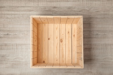 Photo of Open empty wooden crate on light background, top view