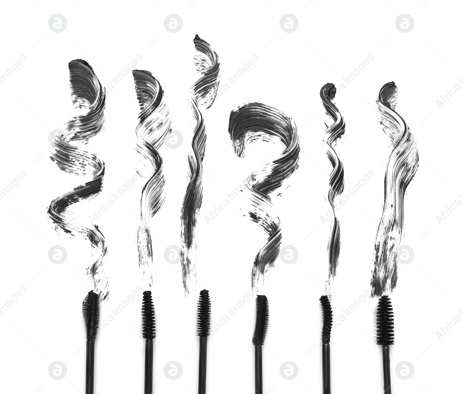 Photo of Different brushes and mascara strokes on white background