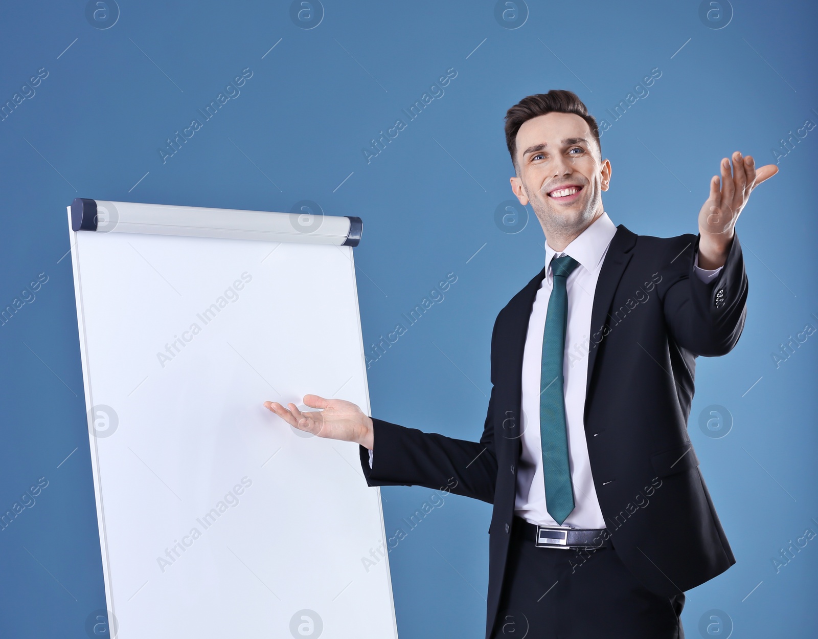 Photo of Young business trainer near flip chart on color background