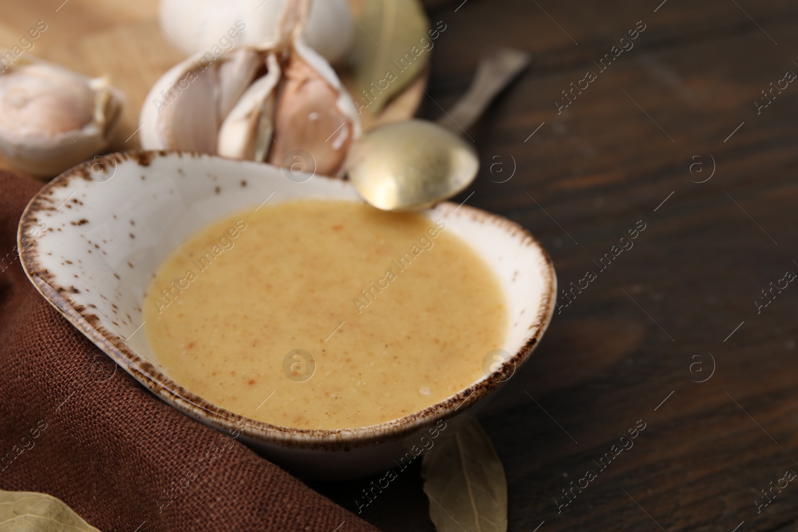 Photo of Delicious turkey gravy served on wooden table, closeup. Space for text