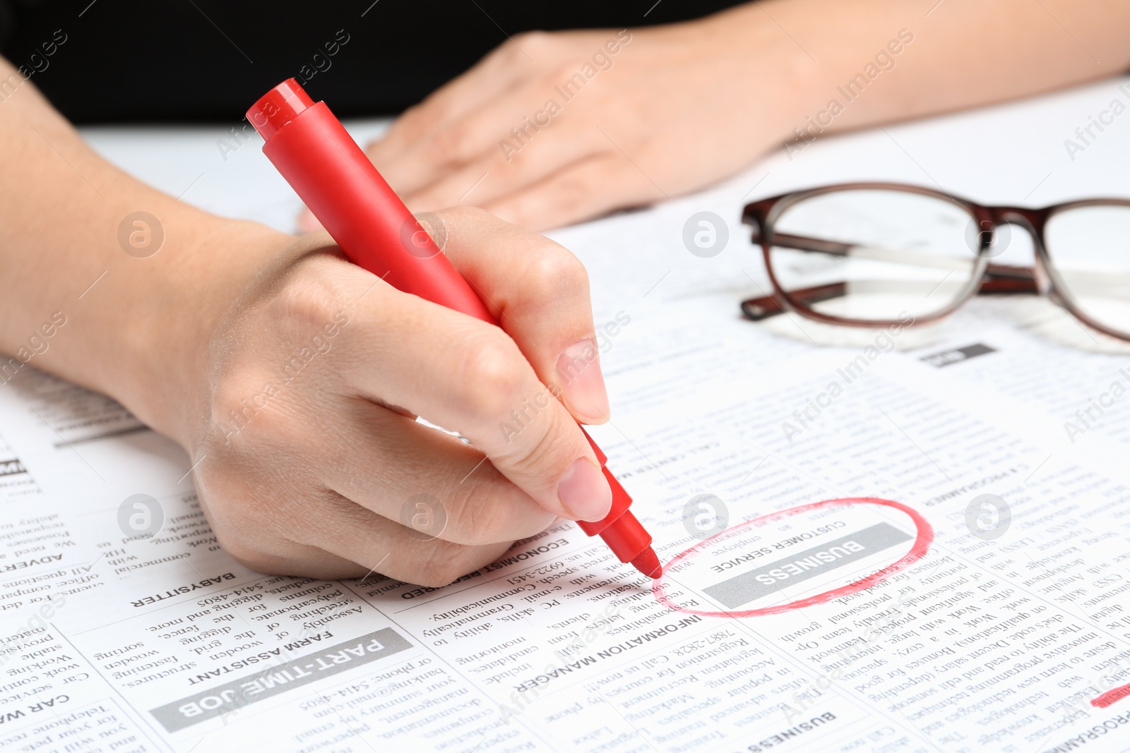 Photo of Woman marking advertisement in newspaper, closeup. Job search concept