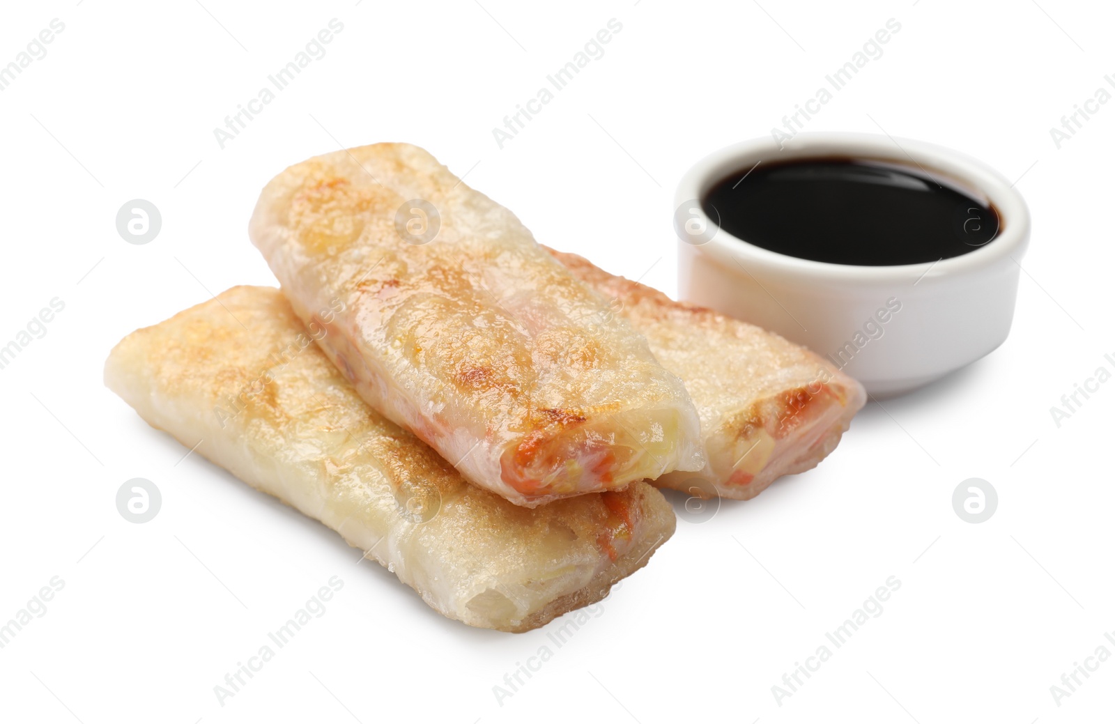 Photo of Delicious fried spring rolls and sauce isolated on white