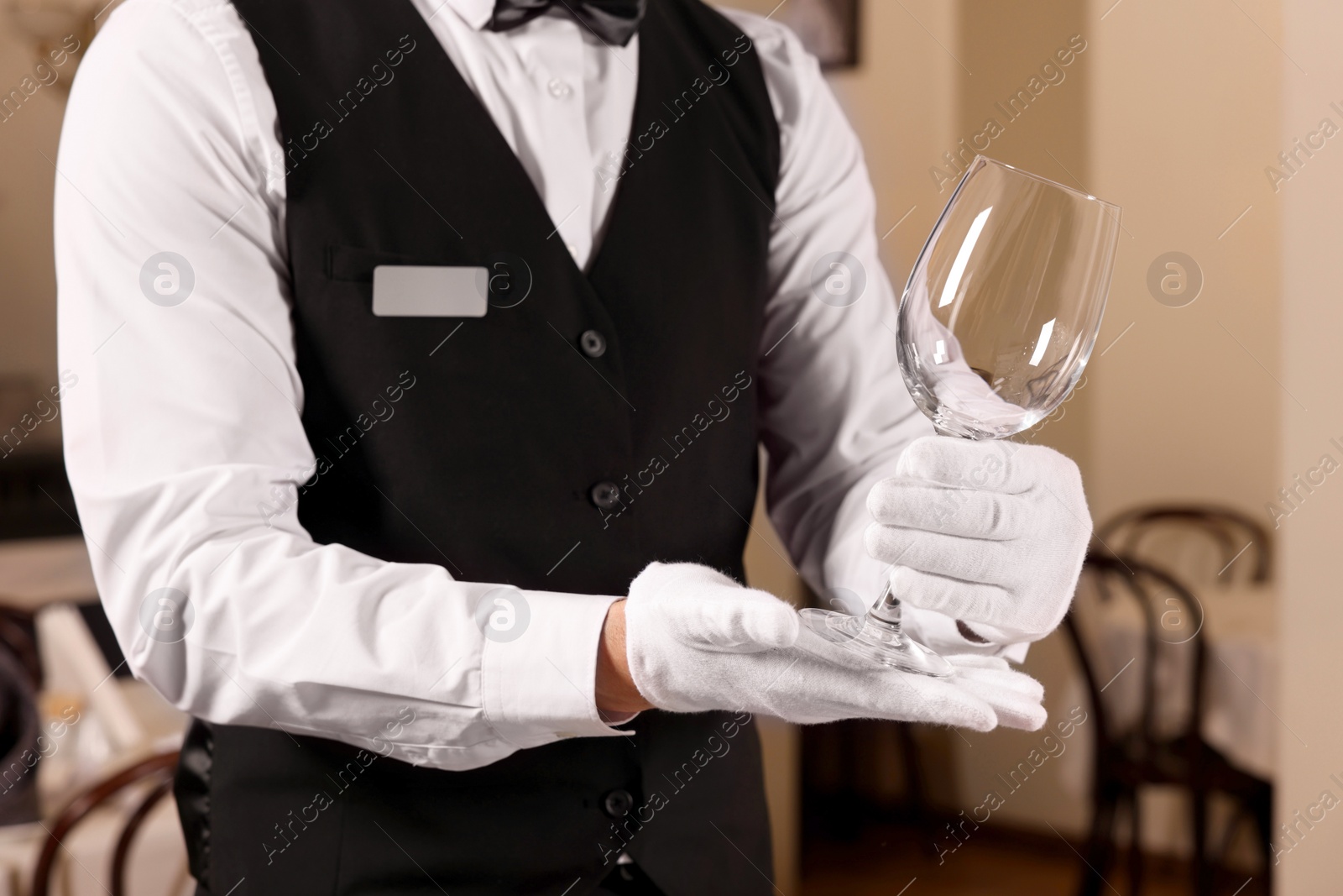 Photo of Man setting table in restaurant, closeup. Professional butler courses