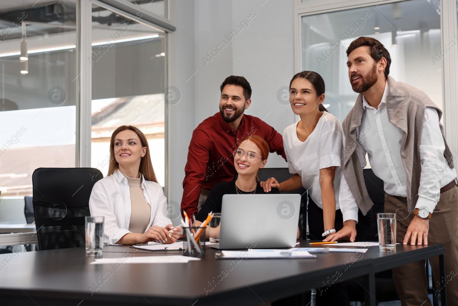 Photo of Team of employees working together in office