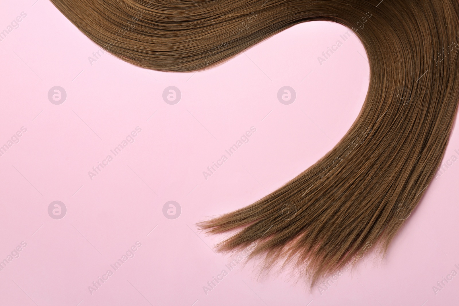 Photo of Beautiful brown straight hair on color background, top view. Space for text