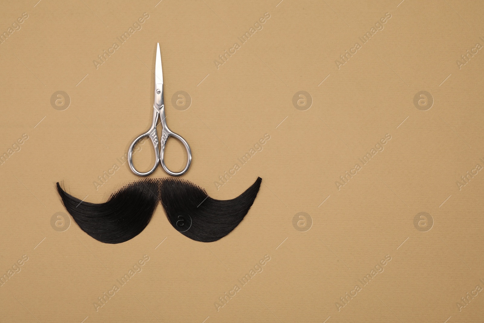 Photo of Artificial moustache and scissors on beige background, top view. Space for text