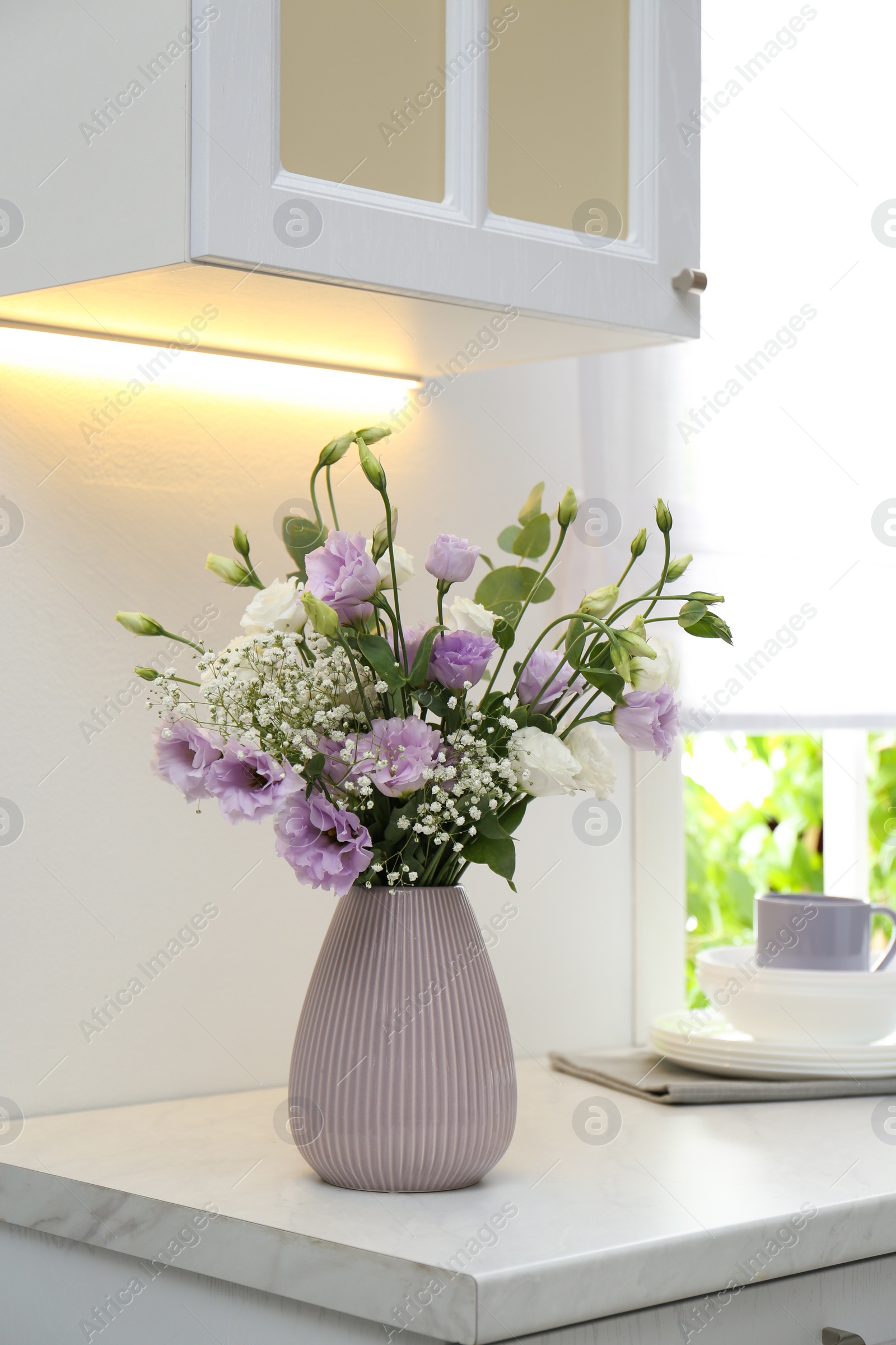 Photo of Beautiful bouquet with Eustoma flowers on countertop in kitchen