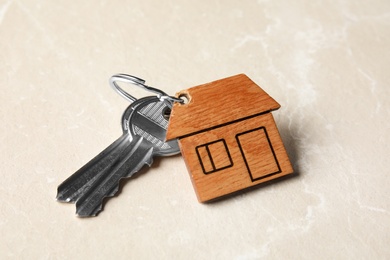 Photo of House keys with trinket on light background