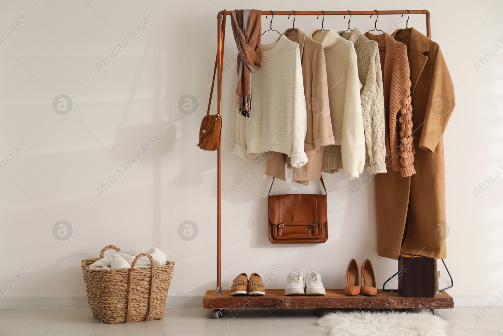 Photo of Modern dressing room interior with rack of stylish shoes and women's clothes