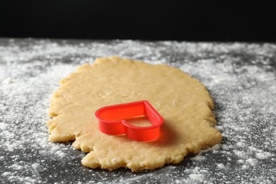 Making shortcrust pastry. Raw dough and cookie cutter on grey table