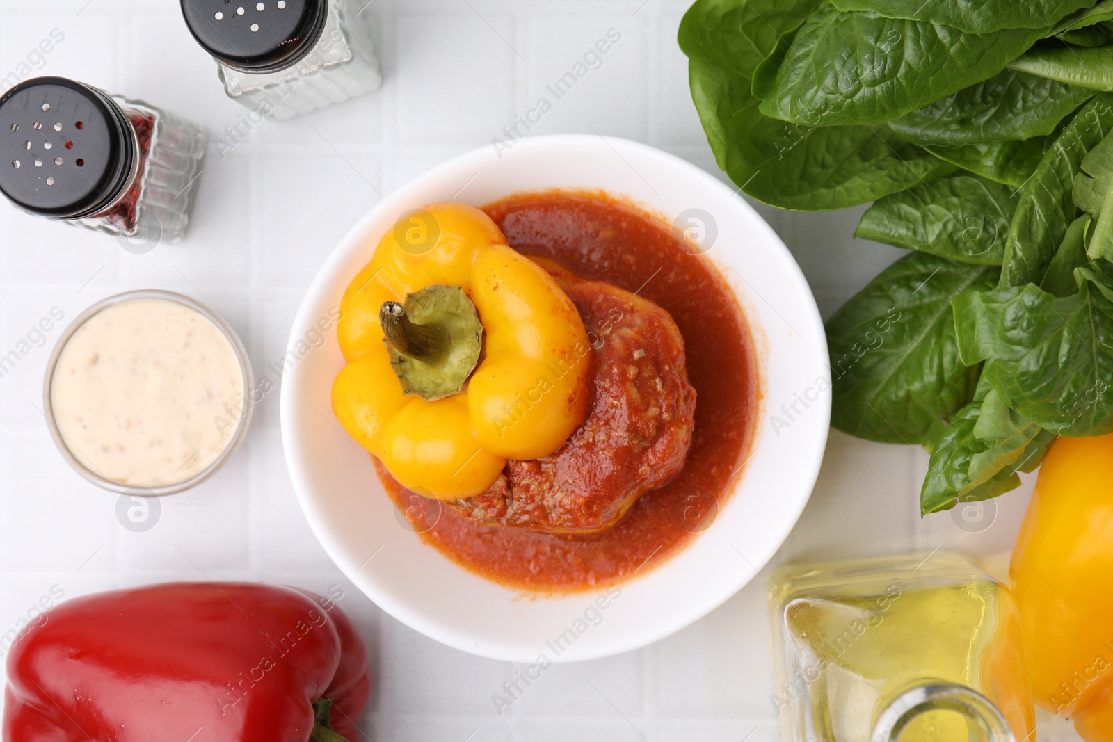 Photo of Delicious stuffed bell pepper served on white tiled table, flat lay