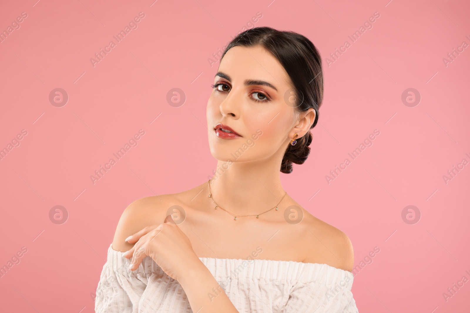 Photo of Beautiful woman with elegant jewelry on pink background