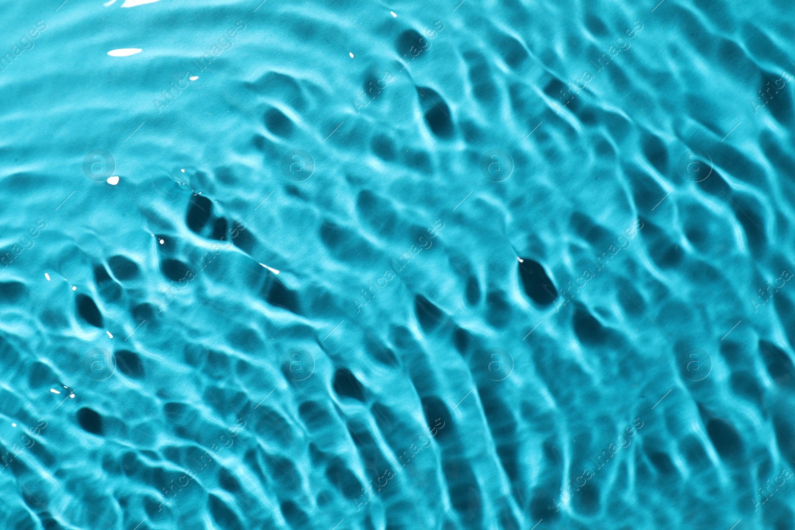 Photo of Rippled surface of clear water on light blue background, top view