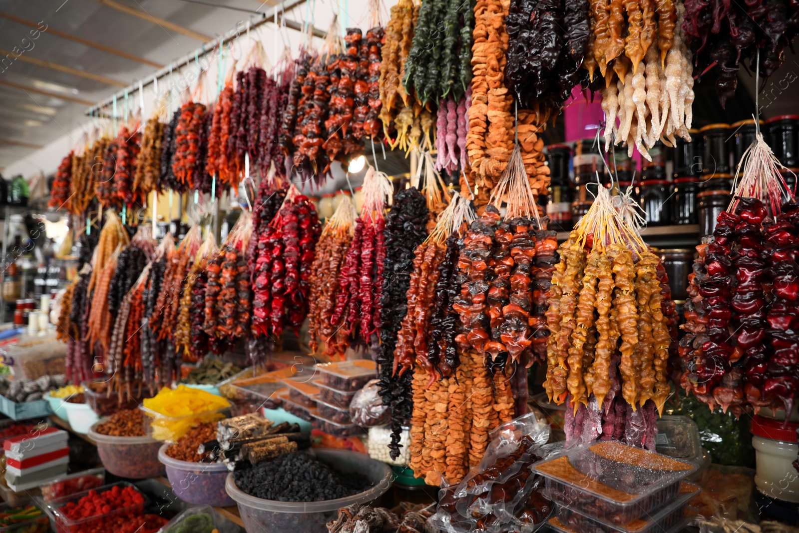 Photo of Bunches of different delicious churchkhelas and dried fruits at market