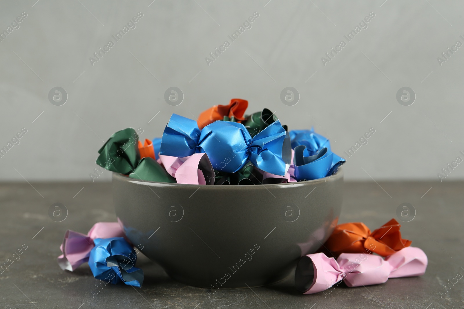 Photo of Candies in colorful wrappers on grey table