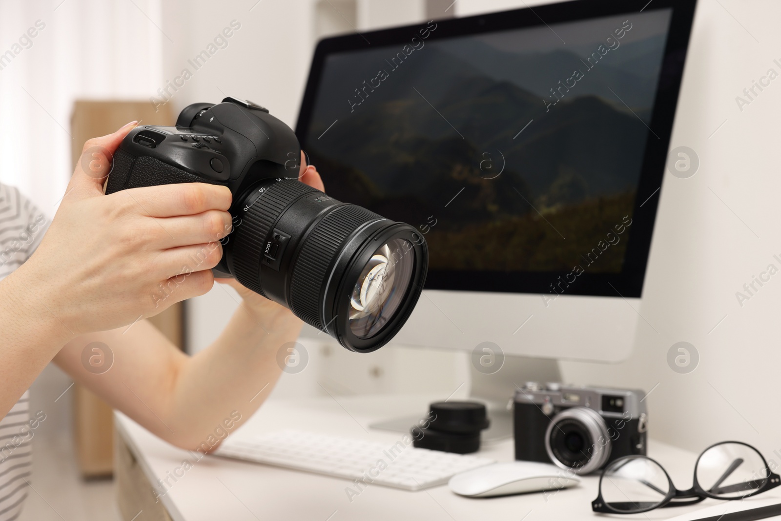 Photo of Photographer with camera at white table indoors, closeup