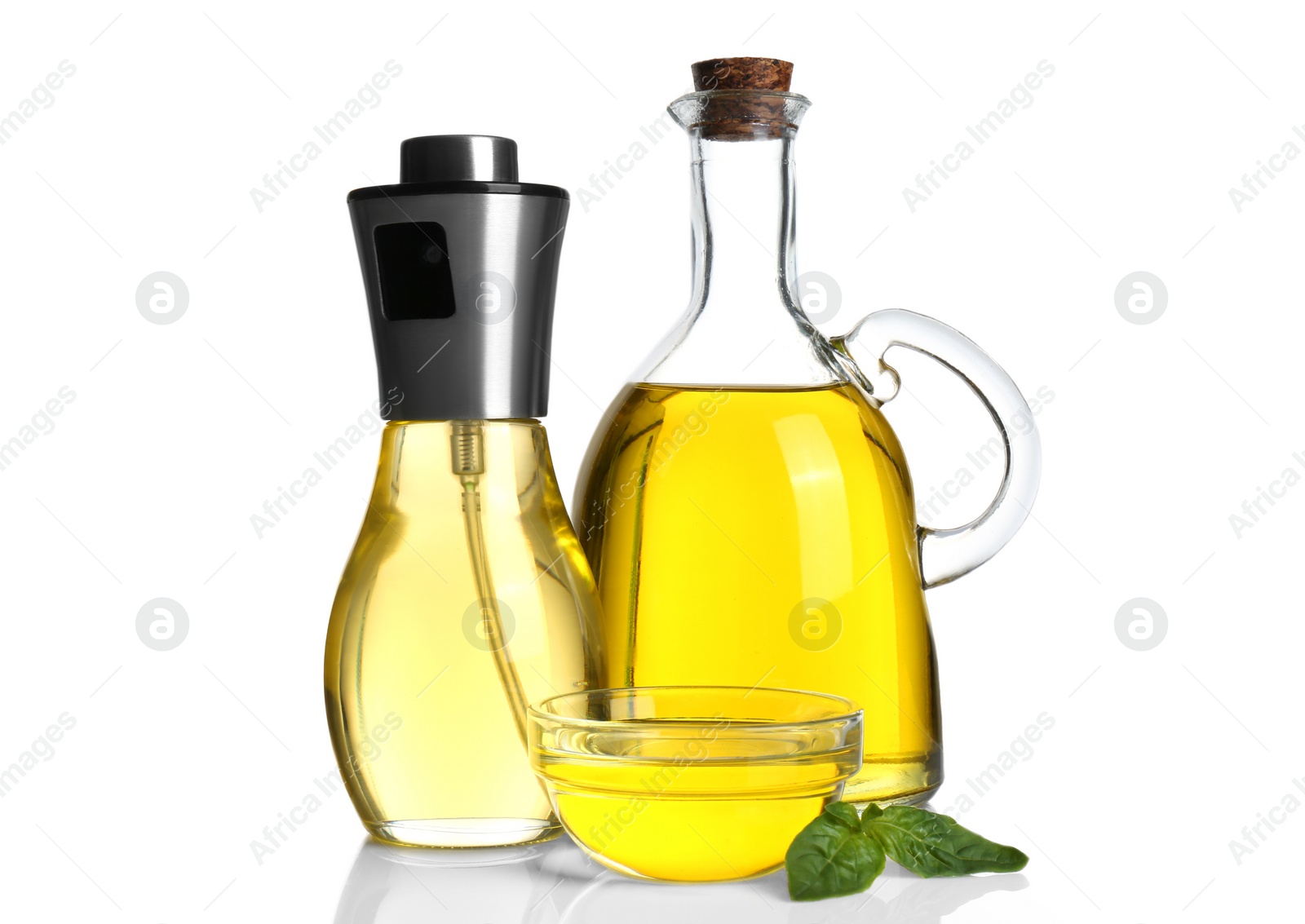 Photo of Cooking oil and basil leaves on white background