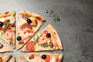 Photo of Tasty pizza with seafood on grey table, flat lay