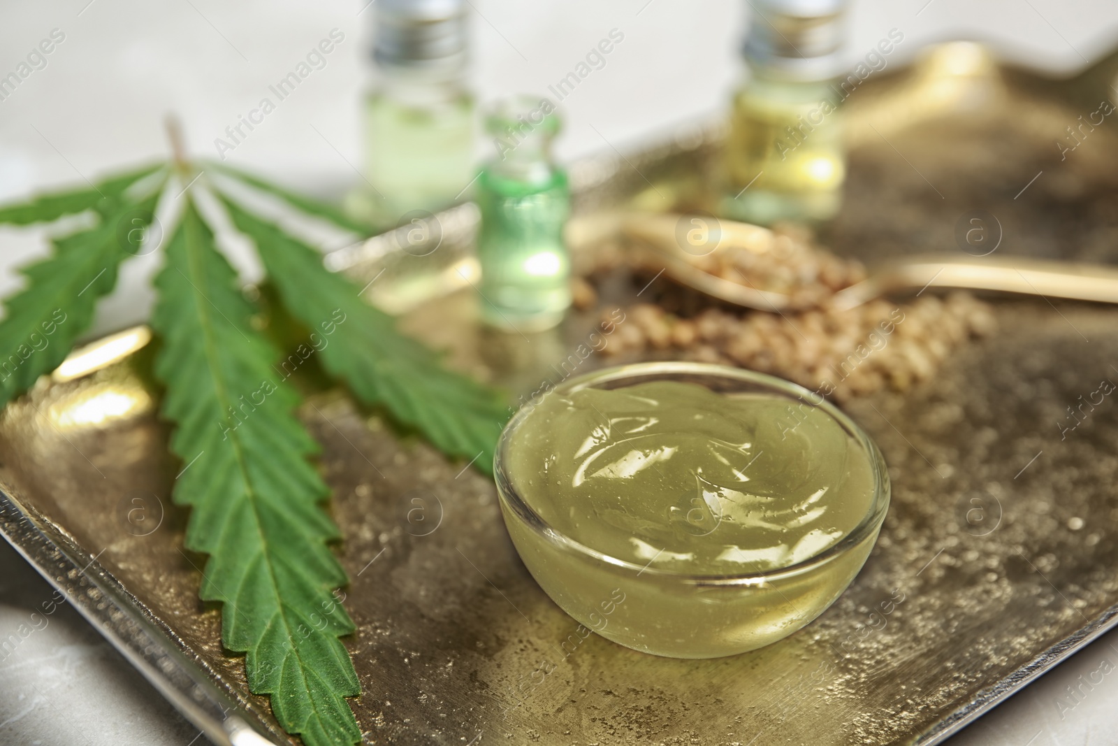 Photo of Bowl with hemp lotion on tray, closeup