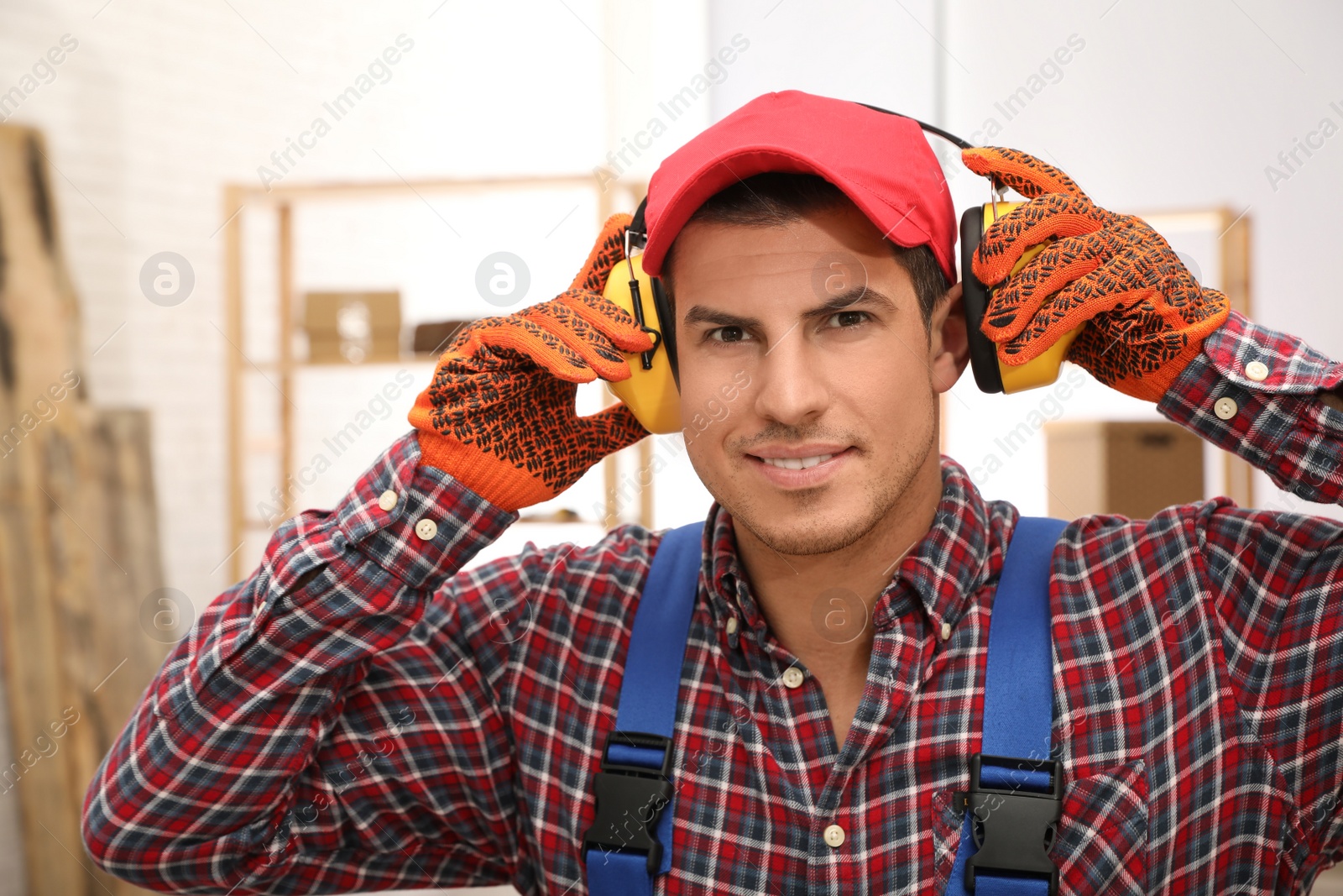 Photo of Worker wearing safety headphones indoors. Hearing protection device